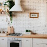 Stylish kitchen interior with modern appliances, wooden counters, and greenery accents.