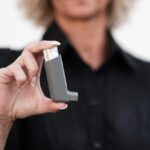 Close-up of a woman holding an asthma inhaler, focusing on respiratory health solutions.