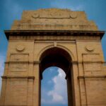 Majestic view of India Gate under a vibrant blue sky in New Delhi, India.