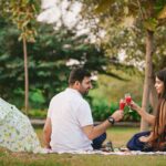 Couple enjoying a romantic picnic outdoors with drinks in a Delhi park.