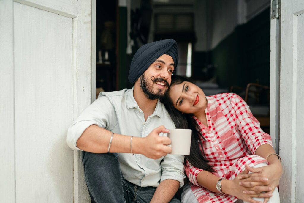 Happy Indian couple relaxing at home with coffee, embracing love and leisure. Perfect for lifestyle and relationship themes.