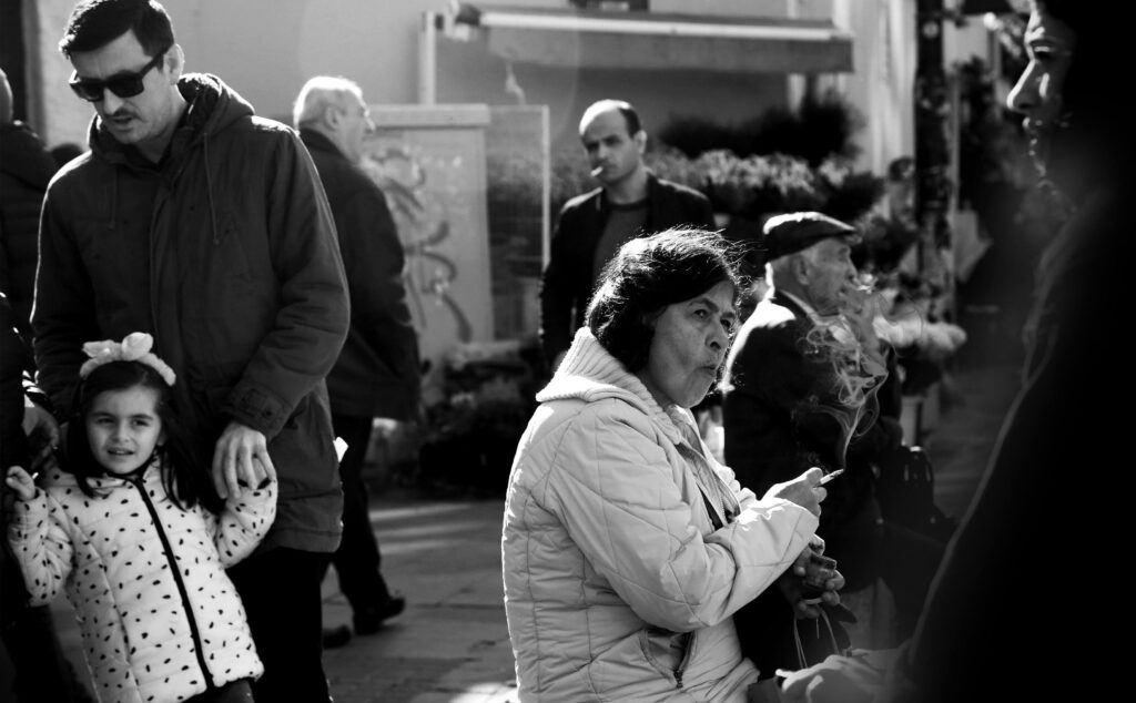 A candid street photo capturing urban life, showing people walking and interacting.