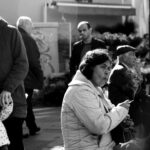 A candid street photo capturing urban life, showing people walking and interacting.