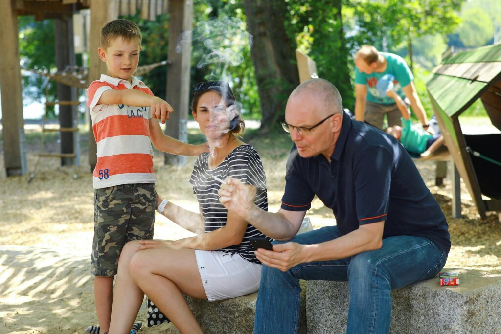 A family enjoying a sunny day at the park, capturing casual moments and interactions.