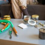 Close-up of a hookah and assorted jars on a table, showcasing recreational use of shisha accessories.